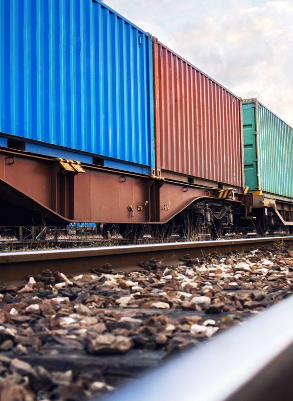 Train wagons carrying cargo containers for shipping companies.